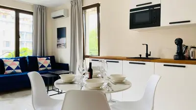 a kitchen and living room with a table and chairs at APARTELLO ARTUR - Modern Studios - Sveti Vlas in Sveti Vlas