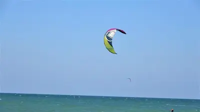 a person flying a kite over the ocean at Seafront Apartment im Obzor Beach Resort in Obzor