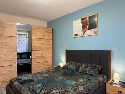 a bedroom with a large bed and a picture on the wall at Briz MK Apartment in Ravda