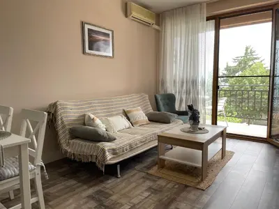 a living room with a couch and a table at Briz MK Apartment in Ravda