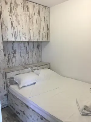a bed with a wooden headboard in a room at Хотел Paradise in Tsarevo