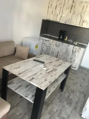 a large wooden table in a room with a couch at Хотел Paradise in Tsarevo