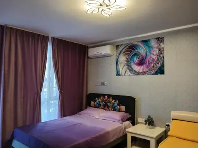 a bedroom with a bed and a painting on the wall at PARUS-2-STUDIO in Pomorie