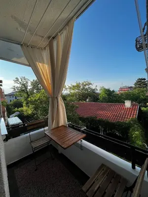 a balcony with a wooden bench and a window at Kъща за гости Христина in Lozenets