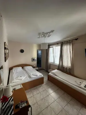 a bedroom with two beds and a window at Kъща за гости Христина in Lozenets