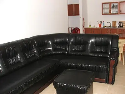 a black leather couch in a living room at Apartamens for rent at the beach bulgaria in Sveti Vlas
