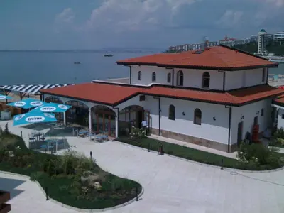 a building with umbrellas in front of the water at Apartamens for rent at the beach bulgaria in Sveti Vlas