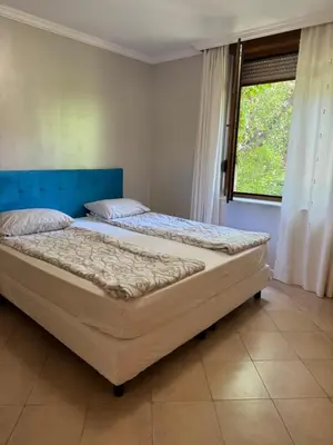 two beds in a bedroom with a window at Santa Marina Apartment 503 in Sozopol