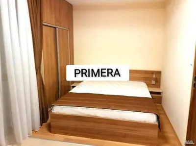 a bed with a sign that says primera in a bedroom at APARTAMENT PRIMERA in Varna City