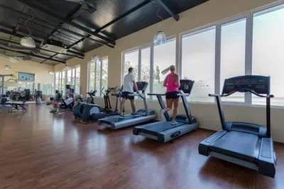 two people walking on treadmills in a gym at DIT Majestic Beach Resort in Sunny Beach