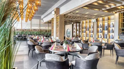 a restaurant with tables and chairs and plants at DIT Majestic Beach Resort in Sunny Beach
