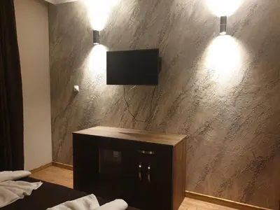 a room with a tv on a wall with two lights at Mit Prot luks Apartment Panorama Bay 2 ap109 in Sveti Vlas