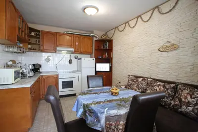 a kitchen with a table and a couch in a room at Апартамент Вангелов in Nesebar