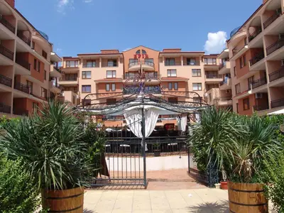 a view of a building with palm trees in front of it at Apart Hotel Efir in Sunny Beach