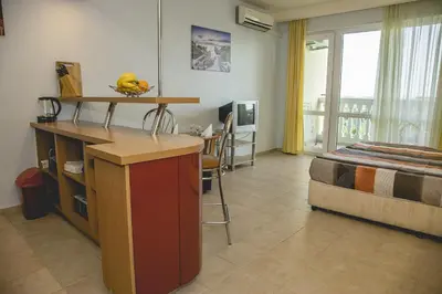 a room with a bed and a kitchen with a counter at Private Studio in Planet Hotel, Sunny Beach Center by Flаt Manаger in Sunny Beach