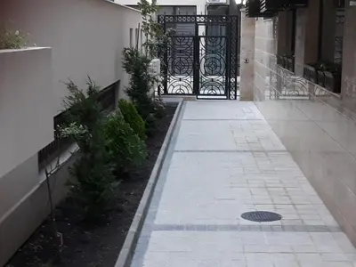 a walkway with a black gate in front of a building at Таня 10 in Pomorie