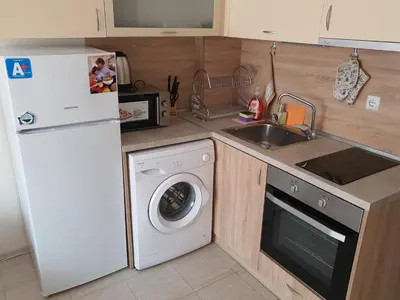 a kitchen with a white refrigerator and a washing machine at Таня 10 in Pomorie