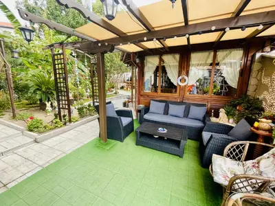 a patio with blue furniture and a pergola at Kastela Guest House in Chernomorets