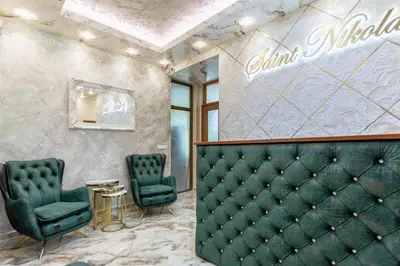 a waiting room with green chairs and a table at Guest rooms Sveti Nikola in Pomorie
