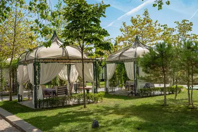 a gazebo with chairs and tables in a park at Menada Apartments in Cascadas in Sunny Beach