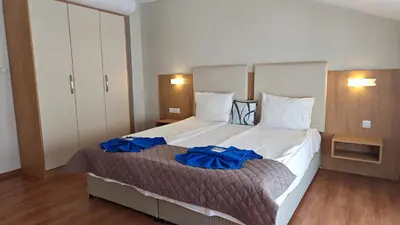 a bedroom with a large bed with blue pillows on it at Family Hotel Milev in Sveti Vlas