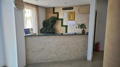 a lobby with a brick wall with plants on it at Family Hotel Milev in Sveti Vlas