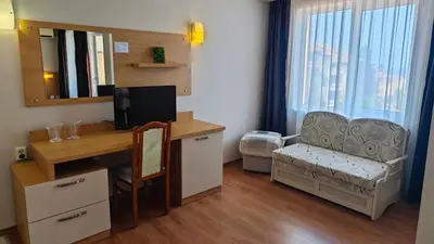 a room with a desk with a computer and a chair at Family Hotel Milev in Sveti Vlas