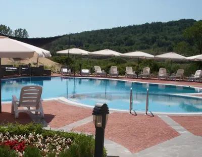 a large swimming pool with chairs and umbrellas at Menada Sozopol Apartments in Sozopol