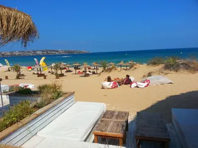 a group of people laying in the sand on the beach at Menada Sozopol Apartments in Sozopol