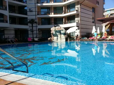 a swimming pool in front of a building at Menada Apartments in Karolina in Sunny Beach