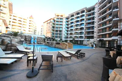 a swimming pool in a building with tables and chairs at Menada Apartments in Karolina in Sunny Beach