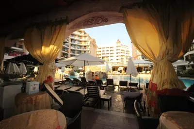 a patio with chairs and umbrellas and a pool at Menada Apartments in Karolina in Sunny Beach