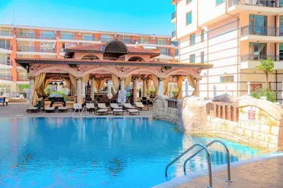 a swimming pool with a gazebo next to a building at Menada Apartments in Karolina in Sunny Beach