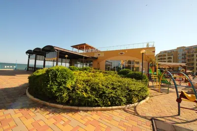 a playground in front of a building next to the ocean at Menada Grand Resort Apartments in Aheloy