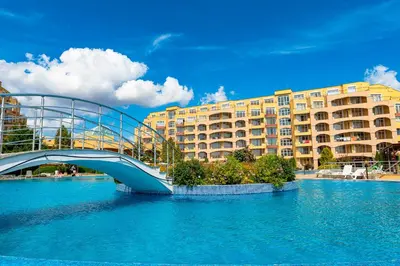 a bridge over a river in front of a building at Menada Grand Resort Apartments in Aheloy