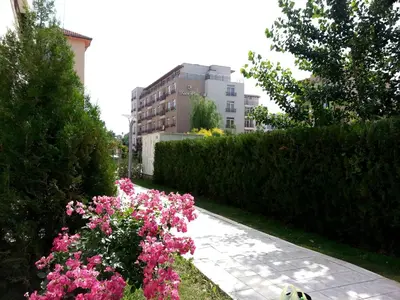 a garden with pink flowers and a hedge at Eden - Menada Apartments in Sunny Beach