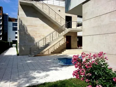 a building with a staircase and some pink flowers at Eden - Menada Apartments in Sunny Beach