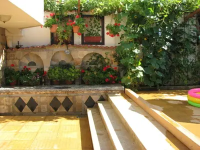 a garden with plants and flowers on a wall at Апартамент КИМАКО 2, 100м2 на цена за хотелска стая за двама in Tsarevo