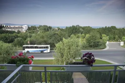 a bus is driving down a road with flowers at Hotel Zaara in Sunny Beach