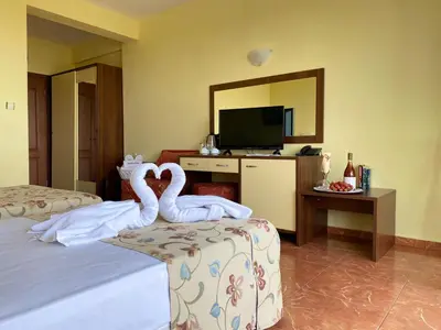 two swans sitting on a bed in a hotel room at Hotel Zaara in Sunny Beach