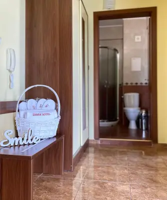 a bathroom with a basket of towels on a bench at Hotel Zaara in Sunny Beach