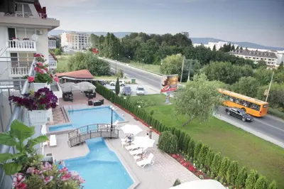 a building with a pool and a street with a bus at Hotel Zaara in Sunny Beach