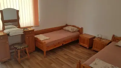a small bedroom with a bed and wooden furniture at Kirovi House - guest rooms in Tsarevo