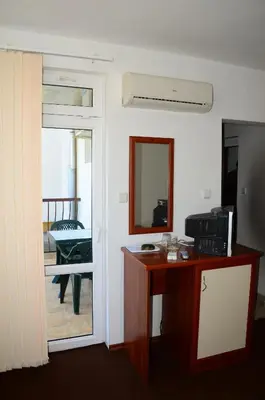 a room with a desk and a door with a mirror at Kirovi House - guest rooms in Tsarevo