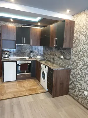 a kitchen with wooden cabinets and a washer and dryer at MitProt Panorama Bay 2 luks apartment 102 in Sveti Vlas