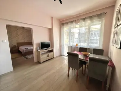 a living room with a dining room table and a bedroom at Studio Thermi 1 in Varna City