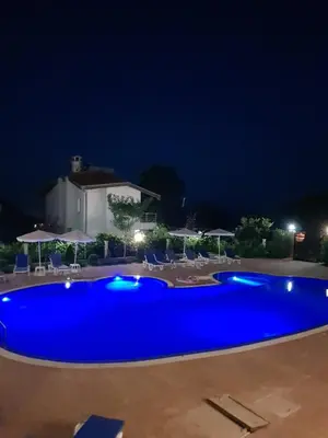 a large blue swimming pool at night at Perla Del Mar Aparthotel in Lozenets
