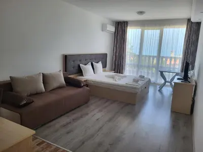 a living room with a couch and a bed at Perla Del Mar Aparthotel in Lozenets