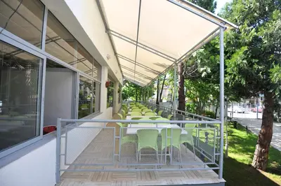 a row of tables and chairs on a porch at Belitsa Hotel in Primorsko
