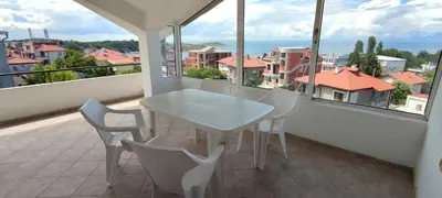 a white table and chairs on a balcony at Yanevi Apartments in Chernomorets